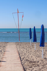 wooden path on the sandy beach leading to the sea against the blue sky