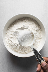 White sugar in a measuring cup, sugar for baking in a cup