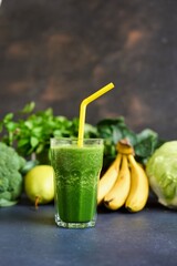 Jars of healthy green smoothie with fresh spinach on grey wooden table, closeup. Detox diet concept: green vegetables on wooden table
