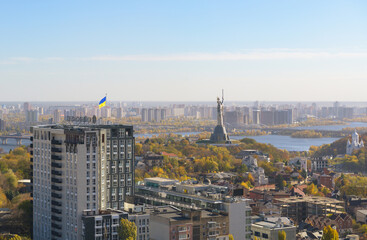 Beautiful panorama of autumn Kiev. View from the left bank to the Dnieper. Wide river in the city and autumn yellow trees.Village and city