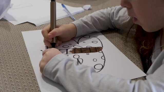 Young girl drawing a butterfly. Doodling with a marker. Little girl making art on paper. Free time. Being creative. Kindergarten. kids hobbies
