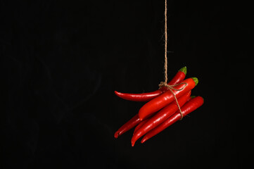 Red pepper hanging on a rope in the kitchen 
