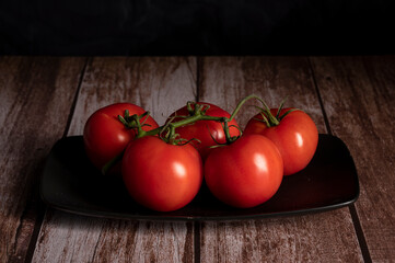 Red tomatoes lie on the table in the kitchen 

