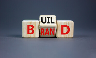 Build your brand symbol. Concept word Build brand on wooden cubes. Beautiful grey table grey background. Business and build your brand concept. Copy space.