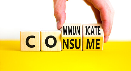 Consume or communicate symbol. Concept word Consume or Communicate on wooden cubes. Beautiful yellow table white background. Businessman hand. Business consume communicate concept. Copy space.