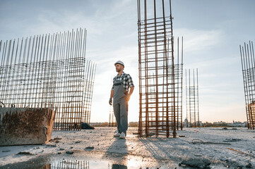 Standing in a beautiful sunlight. Man is working on the construction site at daytime