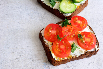 healthy rye bread sandwich with ricotta and tomato slices and curcuma, close-up