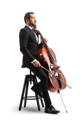 Young male musician in a black suit and bow-tie sitting on a chair with a cello