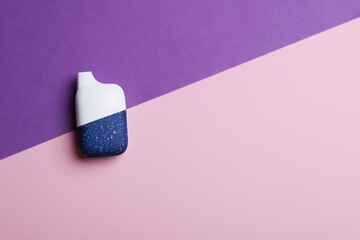 disposable electronic cigarette or vape on purple background. top view copy space. nicotine vapor...
