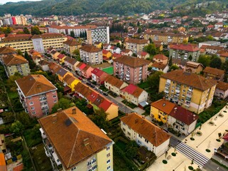 Fototapeta na wymiar Aerial view of a small city from Romania. Apartment buildings, streets and vegetation is depicted in the picture. Name of city: Resita. 