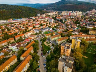  Aerial view of a small city from Romania. Apartment buildings, streets and vegetation is depicted in the picture. Name of city: Resita.
