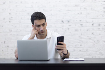 Young handsome businessman working on laptop at home. Distant work concept	