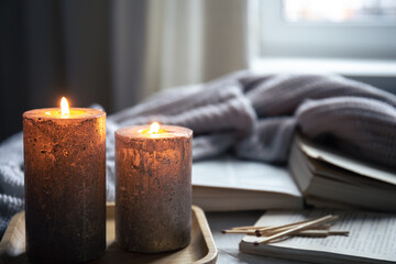 Cozy home composition with candles on a blurred background.