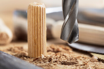 drill bit makes hole in wooden oak board for wooden dowel.