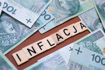 Obraz premium inscription Inflacja next to Polish money. Business background showing price increase in Poland