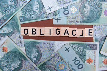 Fototapeta na wymiar the inscription Obligacje next to Polish money. Saving money by buying bonds.