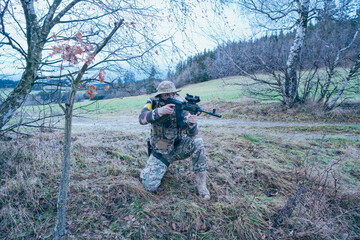 Ukrainian soldier on the front line. With an assault rifle in camouflage. Yellow tape.