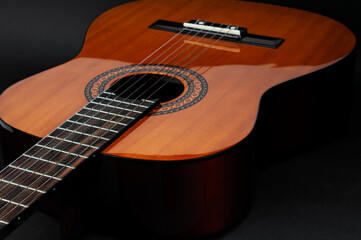 Fototapeta premium Acoustic guitar close up on a black background