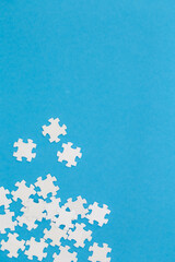 White puzzles on a blue background, flat lay.