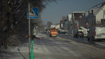 Snow removal in city with special vehicles. Winterdienst in Deutschland. Snowblower clears pavement and bicycle track in Munich, Germany after snowfall in sunny weather. Tractor cleans snowy walkway. 