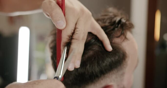 Getting the services of a hairdresser, stylist. Modern haircut in barber shop. Customer Service. Stylish man sitting in barber shop, Hairstylist Hairdresser Male cutting hair with scissors, close-up.