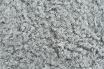 Light gray artificial curly fur texture. Macro. Closeup. Horizontal photo.