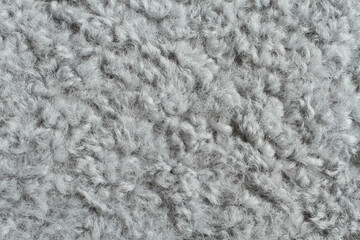 Light gray artificial curly fur texture. Macro. Closeup. Horizontal photo.