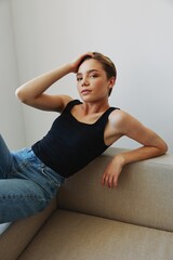 Obraz premium Young woman with short haircut hair having fun at home on the couch smile and happiness, vacation at home, natural posing without filters, free copy space