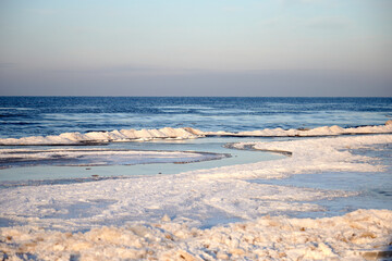 Winter view on the icy sea coast and beautiful calm sky, selective focus