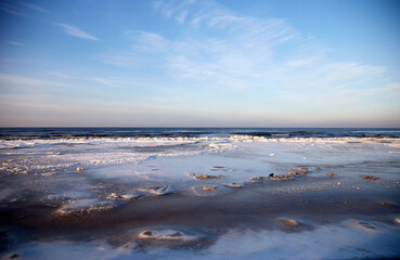 Winter landscape with icy sea coast and calm blue sky, selective focus