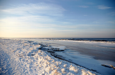 Winter landscape with icy sea coast and calm blue sky, selective focus