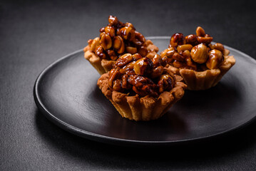 Sweet tasty tart with nuts and honey on a dark concrete background