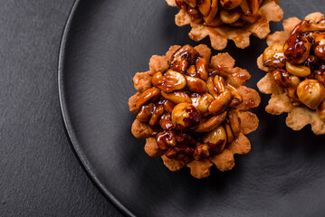Sweet tasty tart with nuts and honey on a dark concrete background
