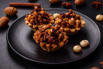 Sweet tasty tart with nuts and honey on a dark concrete background