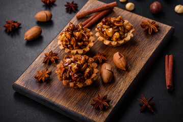 Sweet tasty tart with nuts and honey on a dark concrete background