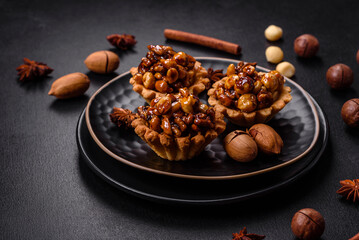 Sweet tasty tart with nuts and honey on a dark concrete background