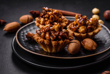 Sweet tasty tart with nuts and honey on a dark concrete background