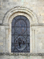 Fototapeta na wymiar Arched stained glass window on the façade