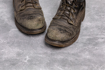 Dirty and scuffed leather work boots. Shoe polish, footwear care and cleaning.