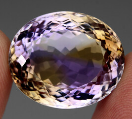 Natural gemstone bi color ametrine on gray background