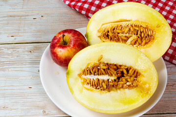 Table of fruits. Melon, papaya, and slices of apple on a wooden table. Selective focus, top view.