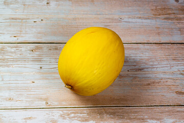 Yellow melon on the wooden table. Selective focus, top view