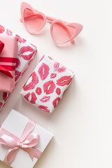 Gift boxes with red bow with heart shaped sunglasses on the white background. Valentine's day concept frame. Copy space