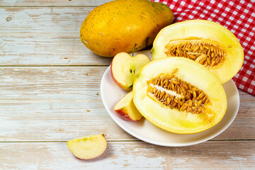 Table of fruits. Melon, papaya, and slices of apple on a wooden table. Selective focus, top view.