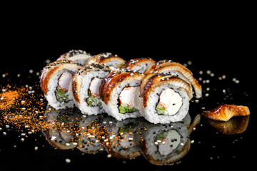 Fresh appetizing sushi with eel, philadelphia cheese, cucumber and sesame, prepared in a Japanese restaurant. © sergo321