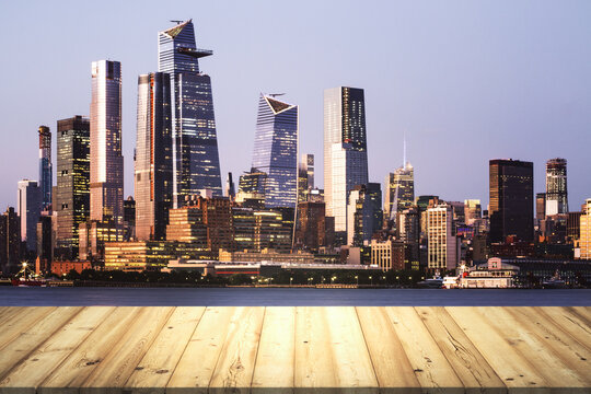 Wooden tabletop with beautiful Manhattan skyscrapers at evening on background, mock up