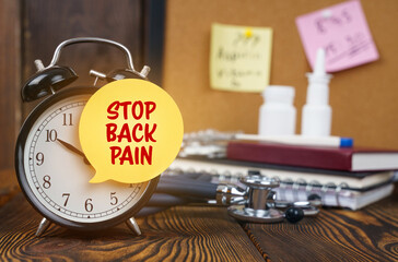 On the alarm clock a sticker with the inscription - STOP BACK PAIN