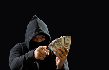 Hacker spy man hands wearing a black shirt, sitting on a chair and a table, is a thief, holding...