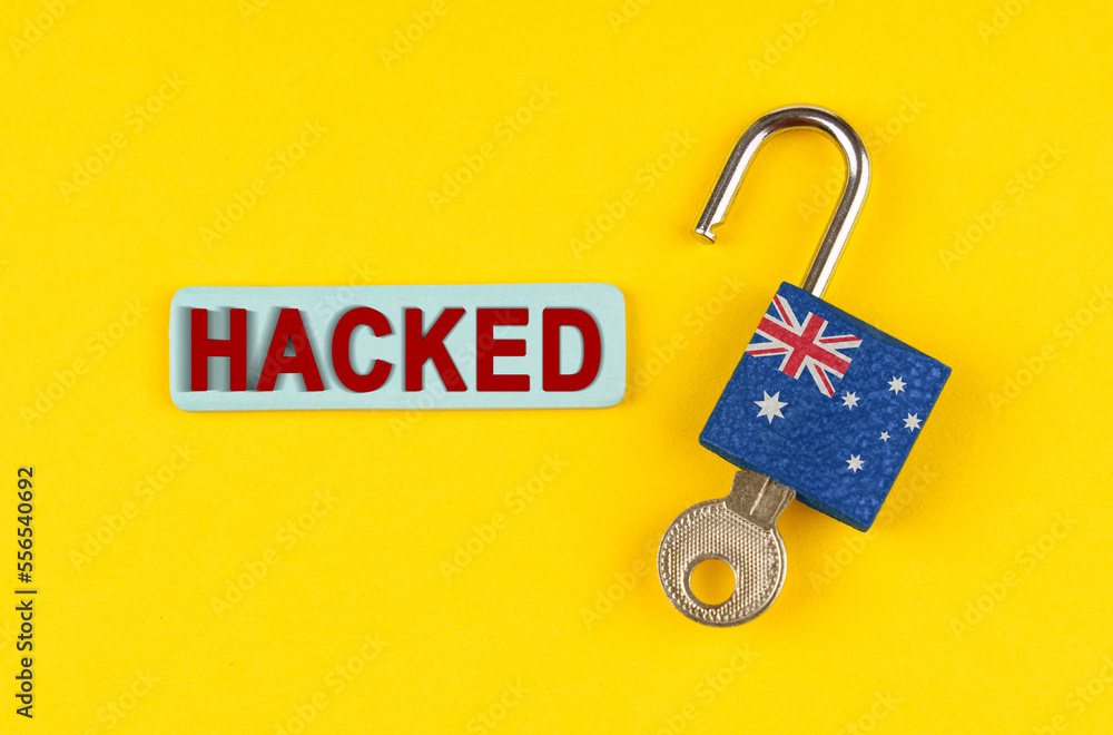Poster on the yellow surface is an open lock with a key and a sticker with the inscription - hacked