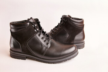 Black leather men's boots on a white background. Warm shoes for winter.